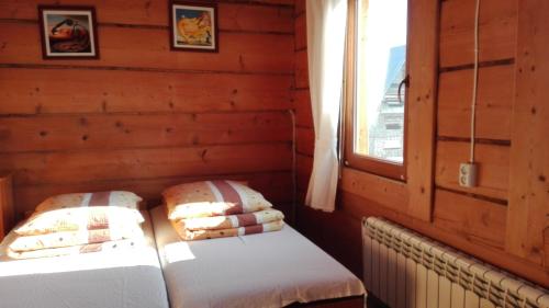 dwa łóżka w pokoju z oknem w obiekcie Chałupka na szlaku Zacisze w Białym Dunajcu