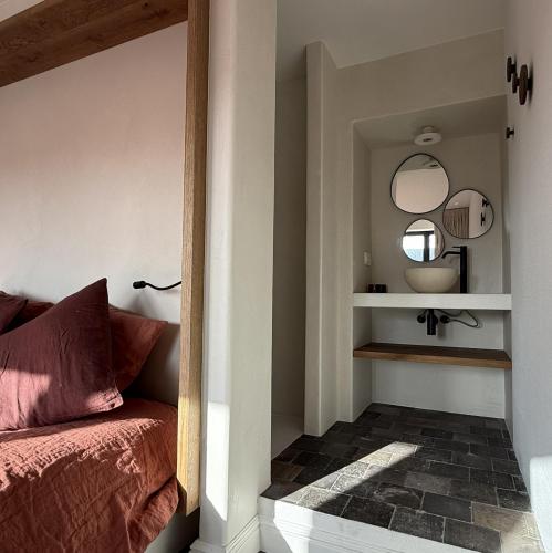 a bedroom with a bed and a mirror on the wall at guesthouse 't Kleihuys in Bruges