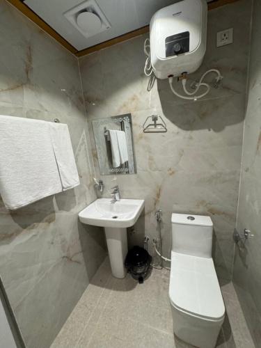 a bathroom with a white toilet and a sink at Hotel Skyline in Janakpur