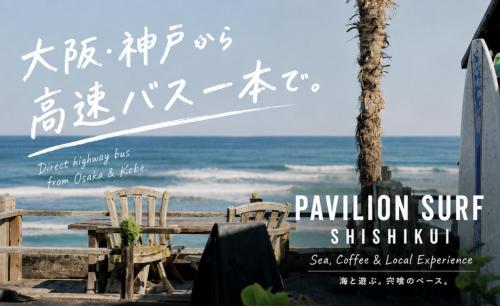 a sign at the beach with a table and chairs at PavilionSurf&Lodge in Shishikui