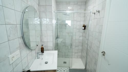 a bathroom with a shower and a sink and a mirror at Casa Las Conchas in La Rábita