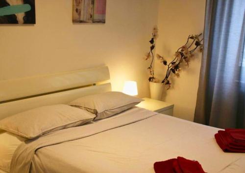 a bedroom with a white bed and a plant at Casa Calipso in Melzo