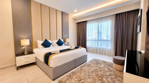 a bedroom with a large bed and a large window at BW Suites & Spa in Juffair