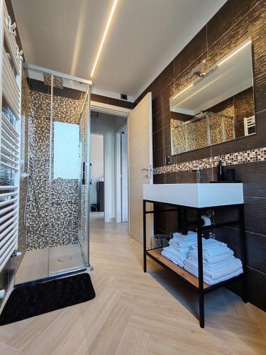 a bathroom with a sink and a glass shower at Manu & Manu Rooms in Garlenda