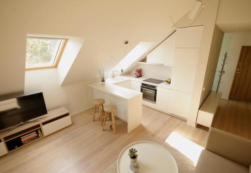 a large white kitchen with a table and chairs at Old Town Apartment with FREE Parking in Marijampolė