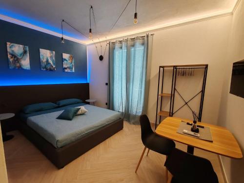 a bedroom with a bed and a desk and a table at Manu & Manu Rooms in Garlenda
