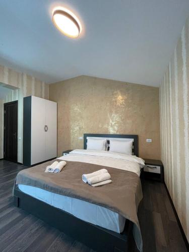 a bedroom with a large bed with two towels on it at Villa san maria in Bakuriani