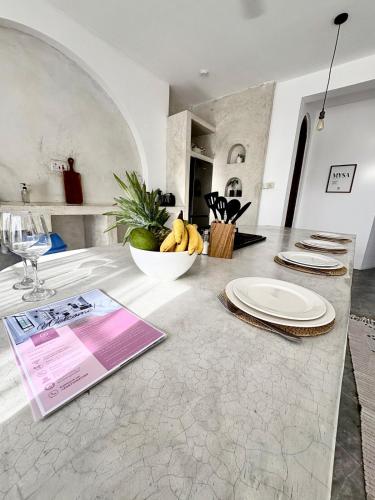 a kitchen counter with plates and a bowl of bananas at Casa Mysa Villas in Michamvi