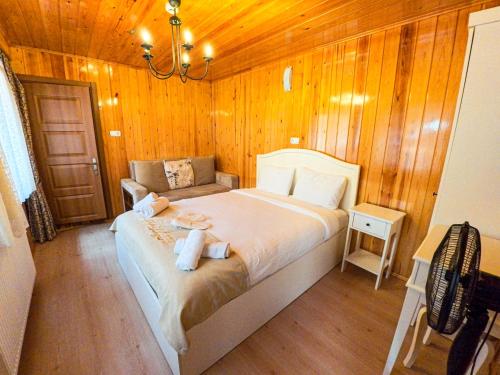 a bedroom with a bed in a wooden wall at ADiLOGLU PANSiYON in Uzungöl