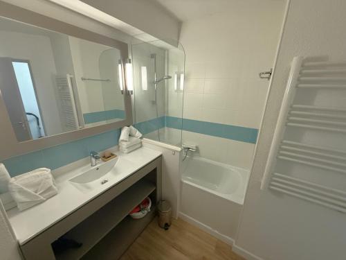 a bathroom with a sink and a mirror and a tub at La Mirande in Collioure