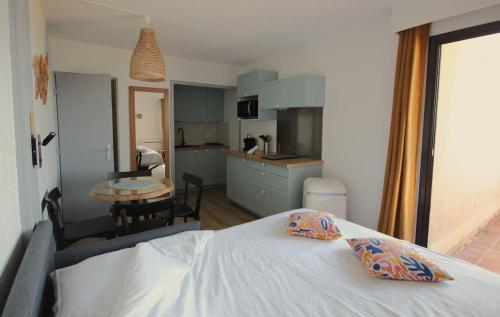 a bedroom with a white bed and a kitchen at La Mirande in Collioure