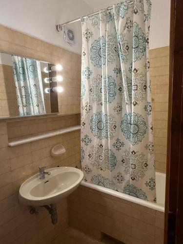 a bathroom with a sink and a shower curtain at Green Quiet Apartments in Vodice