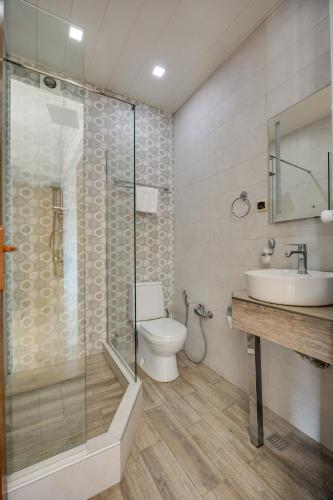 a bathroom with a toilet and a sink and a shower at Hotel Livin in Tbilisi City