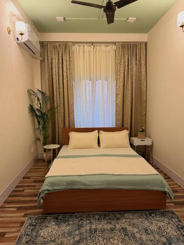 a bedroom with a large bed and a window at Sunshine Stays in Siliguri