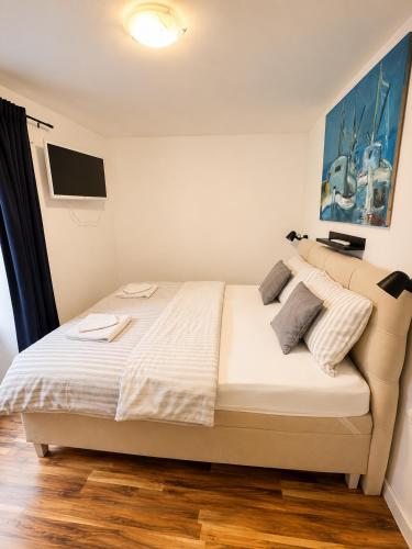 a bedroom with a bed with white sheets and pillows at Apartman Volosko in Opatija