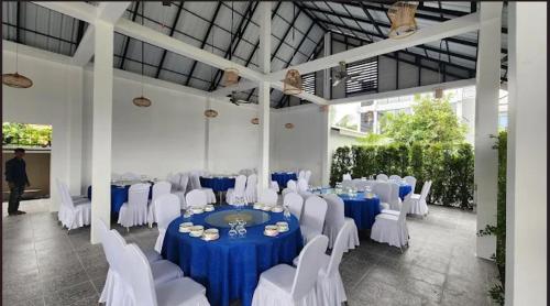 a banquet hall with blue tables and white chairs at Khemra Boutique in Kampot in Kampot