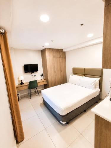 a hotel room with a bed and a desk at Milton Hotel Makati in Manila