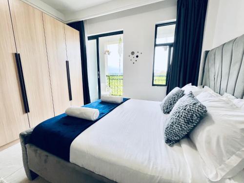 a bedroom with a large bed with a window at Nyvin Haven at The Loftel in Ruaka