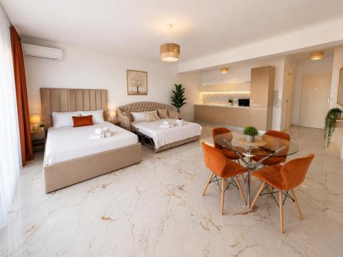 a bedroom with two beds and a table and a couch at LUXURY RESIDENCE Apartments & Studio in Mamaia