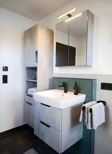 a bathroom with a white sink and a mirror at Kapellenblick Auszeit mit Ausblick in Heroldstatt