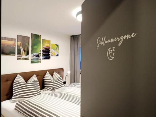 a bedroom with a bed with striped pillows at Kapellenblick Auszeit mit Ausblick in Heroldstatt