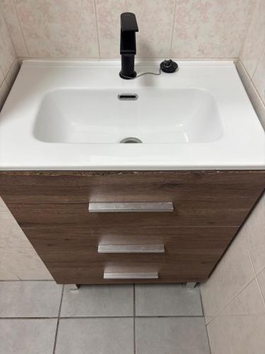 a white sink with a black faucet in a bathroom at San Pedro del Pinatar Lo Pagan, Calle Gibraltar 19 - app 2A in San Pedro del Pinatar