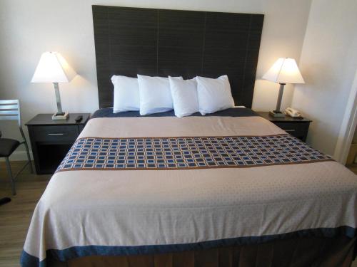 a hotel room with a large bed with two lamps at Budget Inn - Saint Augustine in Saint Augustine
