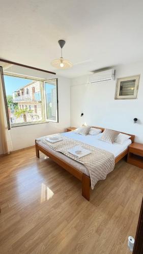 a bedroom with a large bed and a large window at Diving Apartments in Molunat