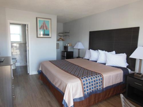 a hotel room with a large bed with white pillows at Budget Inn - Saint Augustine in Saint Augustine