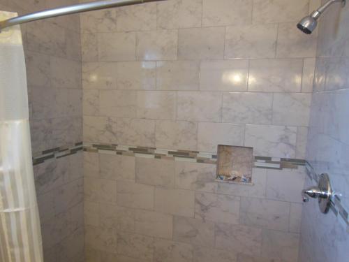 a bathroom with a shower with a tiled shower at Budget Inn - Saint Augustine in Saint Augustine
