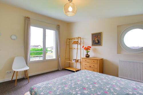 a bedroom with a bed and a window and a dresser at La Houle in Créances