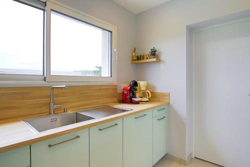 a kitchen with a sink and a window at La Houle in Créances