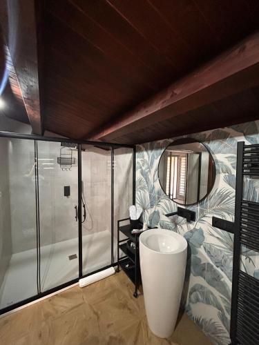 a bathroom with a shower and a sink and a mirror at Sarò rooms in Pietraperzia