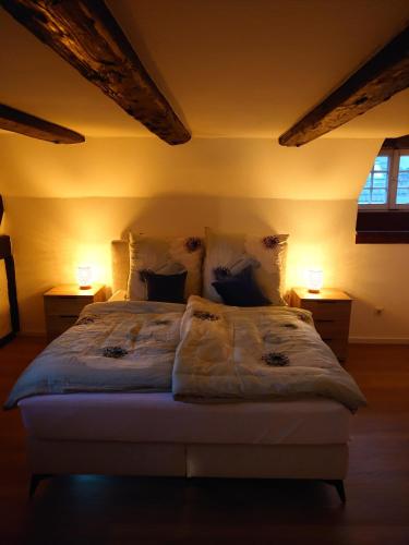 a bedroom with a large bed with two lamps at Denkmal 1764 in Sasbachwalden