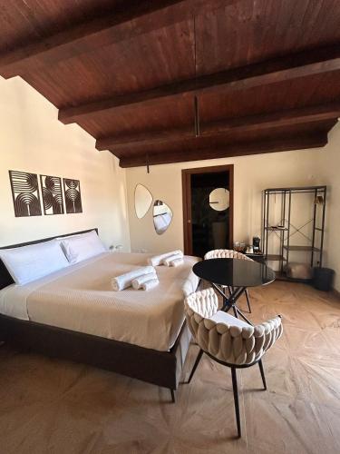 a bedroom with a large bed and a table and chairs at Sarò rooms in Pietraperzia