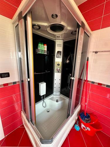a small shower in a room with red walls at Drini river view in Shkodër
