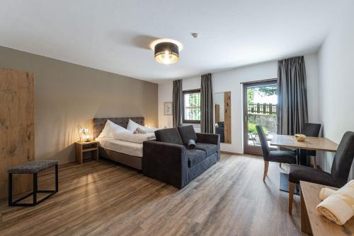 a living room with a bed and a couch and a table at Aparthotel Feldhof Nature in Bolzano