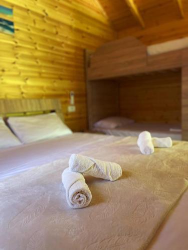 two towels on a bed in a room at Hotel Restorant Natyra Diber Camping in Podgorcë