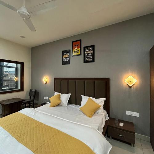 a bedroom with a large bed with yellow pillows at Wellawing Regency Samrala Chownk in Ludhiana