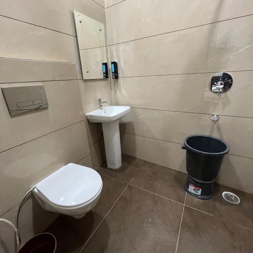 a bathroom with a toilet and a sink at Wellawing Regency Samrala Chownk in Ludhiana