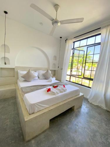 a bedroom with a large bed with a large window at Casa Mysa Villas in Michamvi