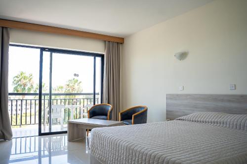 a hotel room with a bed and a balcony at Veronica Hotel in Paphos