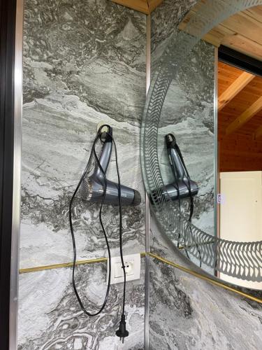 a wall with a hose attached to a stone wall at Hotel Restorant Natyra Diber Camping in Podgorcë