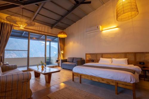 a bedroom with a large bed and a living room at Over The World in Rāmgarh