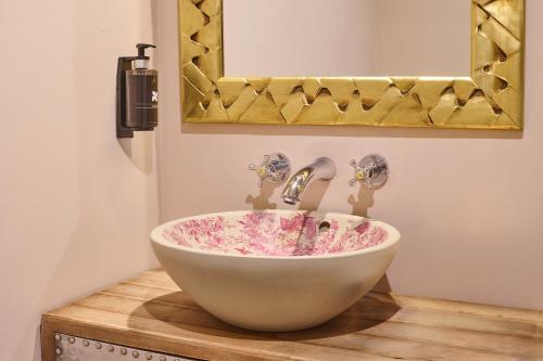 a bathroom with a bowl sink and a mirror at Apartamentos Luna Suites Palacio Almagra in Granada