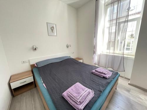 a bedroom with a bed with purple towels on it at Villa History in Crikvenica