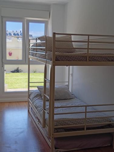 two bunk beds in a room with a window at Apartamento en Playa de Altar in Barreiros