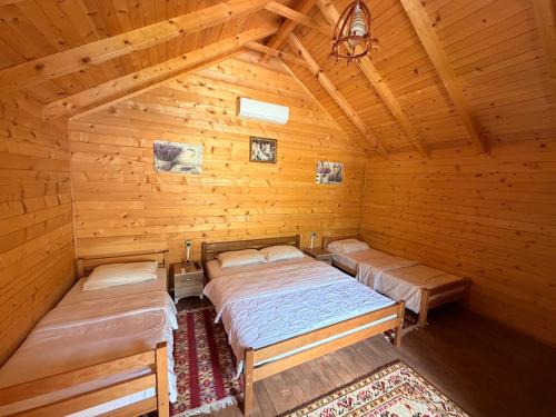 a bedroom with two beds in a wooden cabin at Valbone Two E in Valbonë