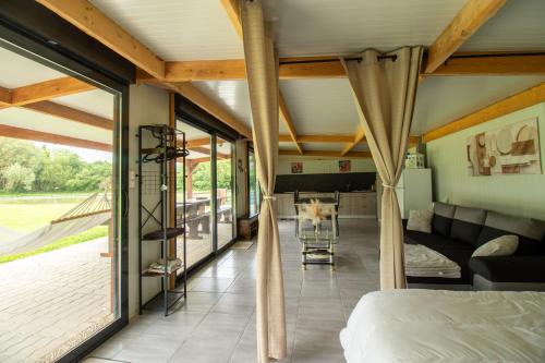 a bedroom with a bed and a living room at Aux étangs in Brutelles