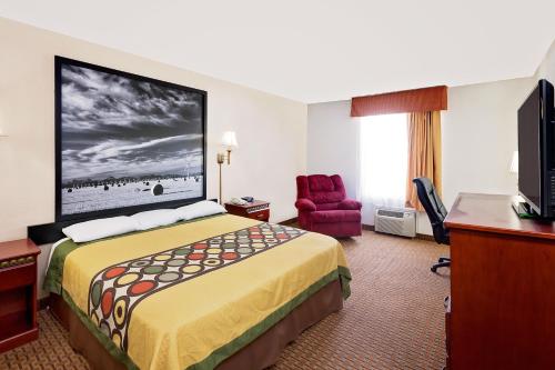 a hotel room with a bed and a flat screen tv at Super 8 by Wyndham Plainview in Plainview